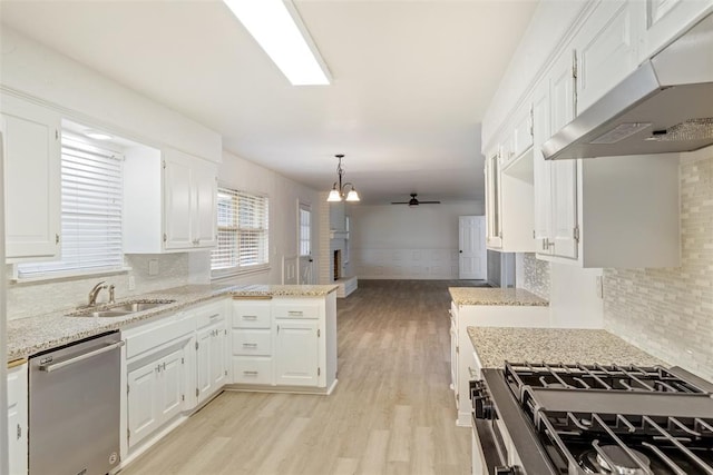 6200 N Styll Rd, Oklahoma City, OK 73112 - kitchen featuring under cabinet range hood, stainless steel appliances, a sink, a peninsula, and decorative backsplash