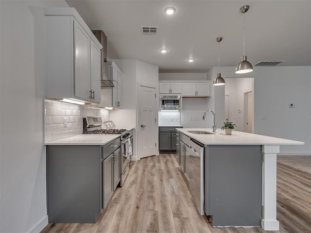 kitchen featuring visible vents, light wood-type flooring, a sink, and appliances with stainless steel finishes
