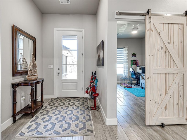 21608 SE 95th St, Mcloud, OK 74851 - entryway featuring light wood-style flooring, a barn door, and baseboards