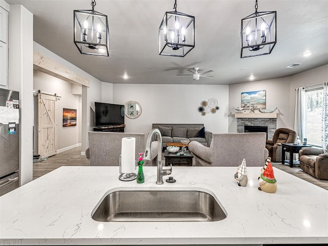 21608 SE 95th St, Mcloud, OK 74851 - kitchen featuring a sink, open floor plan, a chandelier, a barn door, and ceiling fan
