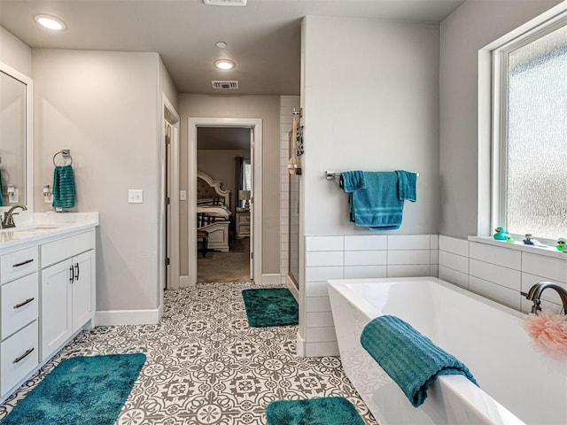 21608 SE 95th St, Mcloud, OK 74851 - ensuite bathroom featuring vanity, a bath, healthy amount of natural light, tile patterned flooring, and recessed lighting