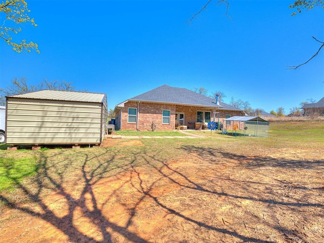 21608 SE 95th St, Mcloud, OK 74851 - rear view of property with an outdoor structure, brick siding, and a lawn