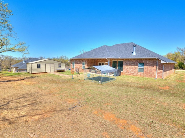 21608 SE 95th St, Mcloud, OK 74851 - rear view of property featuring brick siding, an outdoor structure, a shingled roof, and a lawn