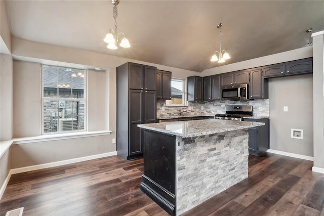 kitchen with backsplash, an inviting chandelier, appliances with stainless steel finishes, and hanging light fixtures