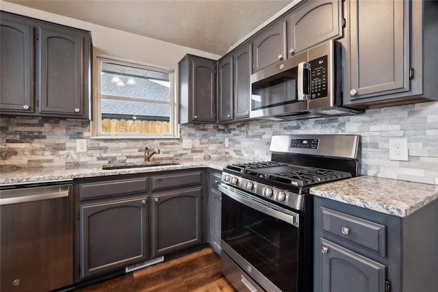 kitchen featuring tasteful backsplash, stainless steel appliances, visible vents, and a sink