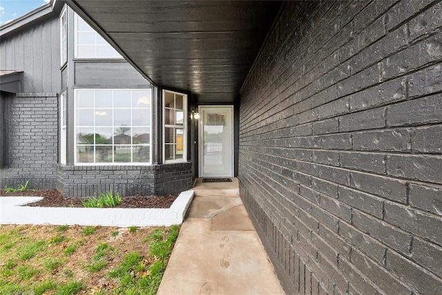 doorway to property featuring brick siding