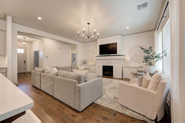 living room featuring visible vents, a notable chandelier, ornamental molding, recessed lighting, and hardwood / wood-style floors