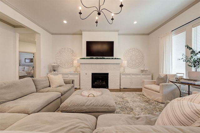 living room with crown molding, a fireplace, recessed lighting, a chandelier, and wood finished floors