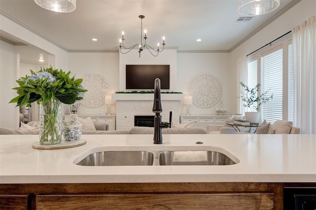 kitchen featuring open floor plan, visible vents, a sink, and crown molding