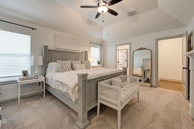 bedroom featuring connected bathroom, a ceiling fan, visible vents, light carpet, and lofted ceiling