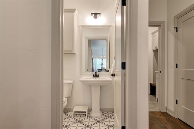 bathroom with baseboards, a sink, and toilet