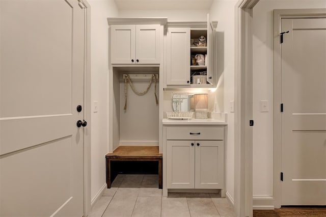 mudroom with light tile patterned floors and baseboards