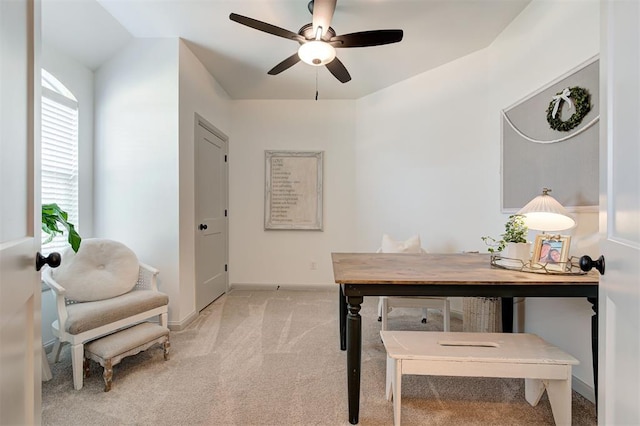 office featuring light carpet, baseboards, and a ceiling fan