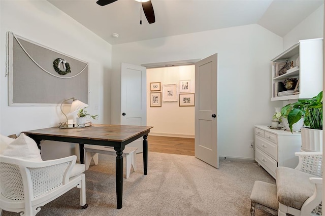 office area featuring light colored carpet, vaulted ceiling, and ceiling fan