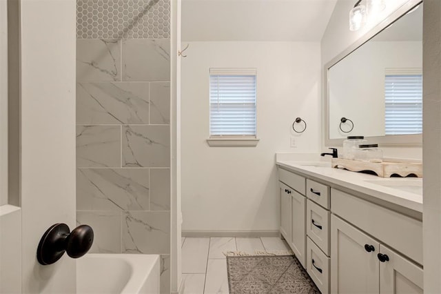 full bathroom with tub / shower combination, marble finish floor, a sink, double vanity, and baseboards