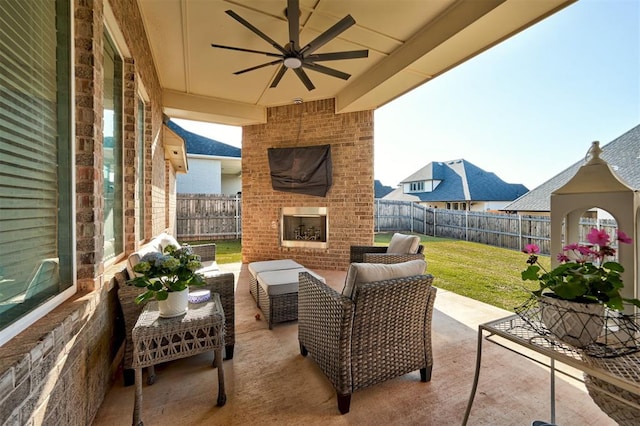 view of patio with a fenced backyard, an outdoor living space with a fireplace, and a ceiling fan