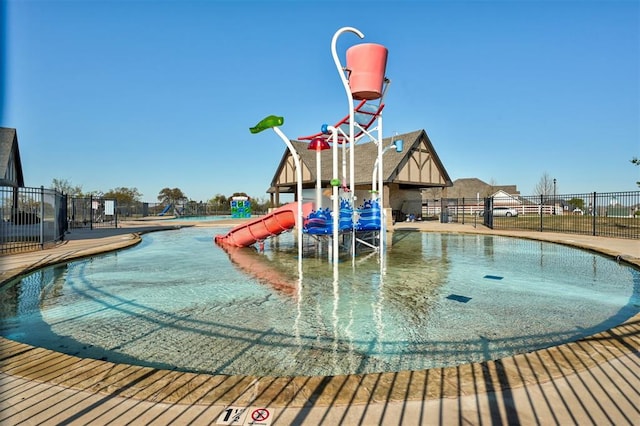 view of pool with fence and playground community