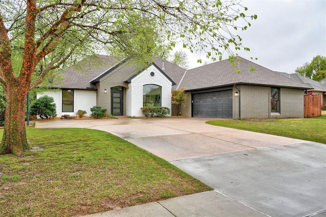 view of front facade with brick siding, concrete driveway, a garage, and a shingled roof