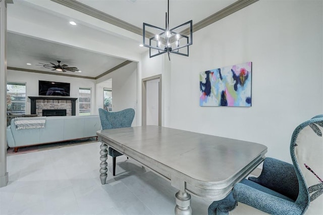 dining space with ceiling fan with notable chandelier, a fireplace, recessed lighting, and ornamental molding