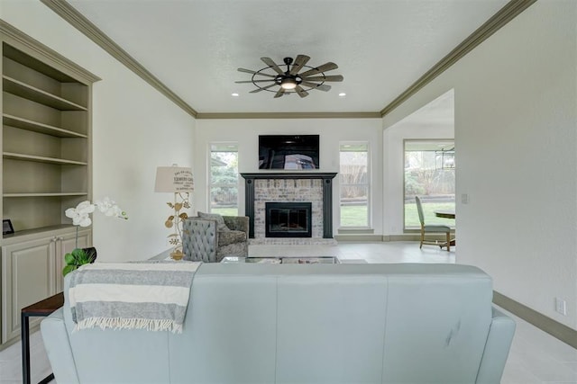 living area with built in features, a ceiling fan, crown molding, and a brick fireplace
