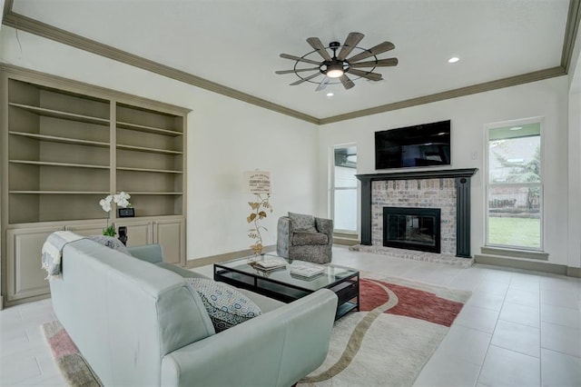 living room featuring a brick fireplace, baseboards, ornamental molding, and a ceiling fan