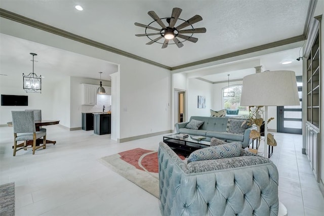 living area featuring ceiling fan with notable chandelier, crown molding, baseboards, and a textured ceiling