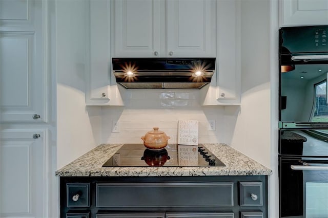 kitchen with light stone counters, backsplash, white cabinetry, exhaust hood, and black appliances