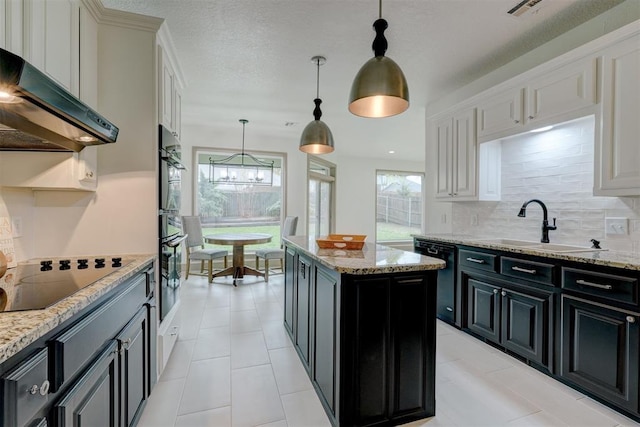 kitchen featuring range hood, a kitchen island, dark cabinetry, black appliances, and backsplash