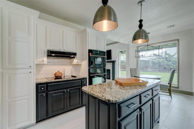 kitchen with white cabinetry, light stone countertops, under cabinet range hood, visible vents, and black appliances