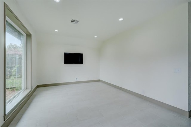 spare room featuring baseboards, visible vents, a healthy amount of sunlight, and recessed lighting