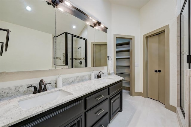 full bath featuring double vanity, a sink, and a stall shower