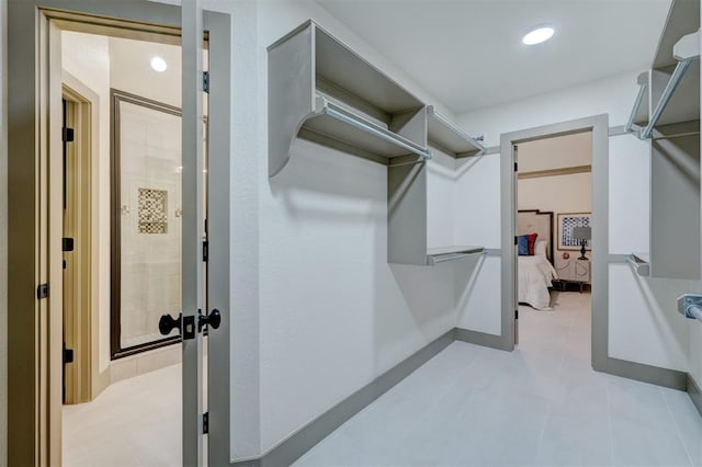 walk in closet with light tile patterned flooring
