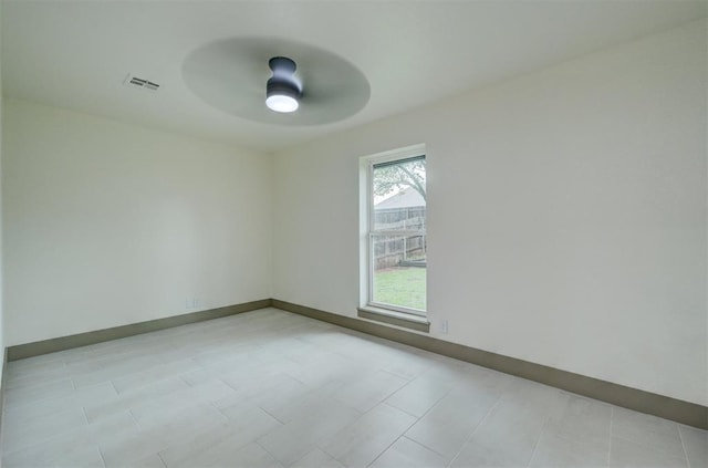 spare room featuring baseboards, ceiling fan, and visible vents