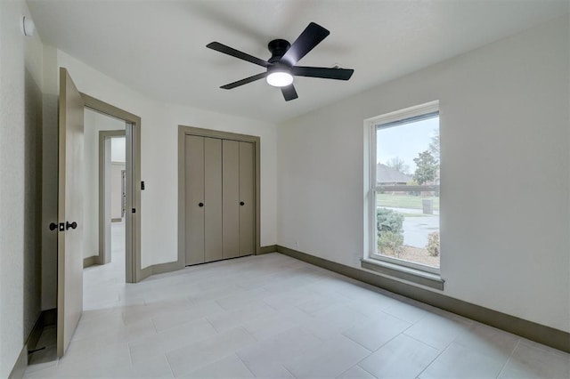 unfurnished bedroom featuring baseboards, a closet, and ceiling fan