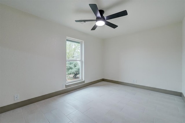 unfurnished room featuring a ceiling fan and baseboards