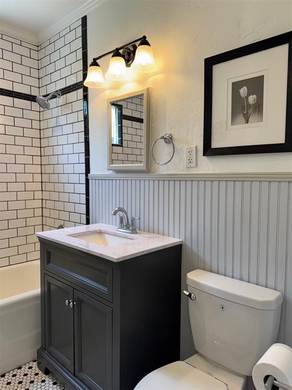 2252 NW 37th St, Oklahoma City, OK 73112 - full bathroom featuring vanity, tub / shower combination, and a wainscoted wall