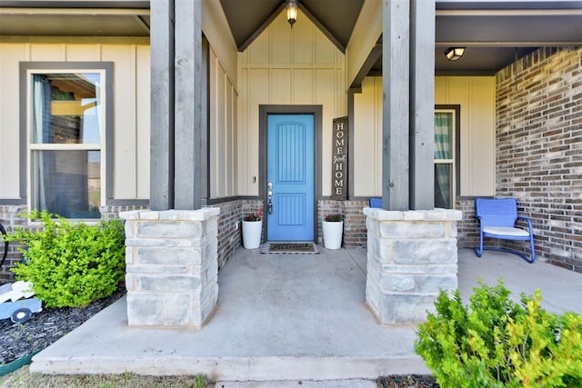 31352 Landrun Ave, Norman, OK 73072 - view of exterior entry with covered porch, brick siding, and board and batten siding