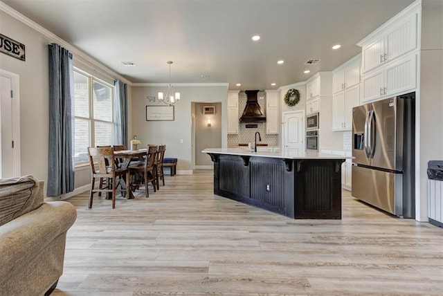 31352 Landrun Ave, Norman, OK 73072 - kitchen with appliances with stainless steel finishes, custom range hood, a chandelier, light countertops, and white cabinetry