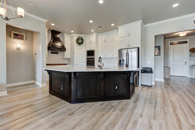 31352 Landrun Ave, Norman, OK 73072 - kitchen featuring appliances with stainless steel finishes, premium range hood, light countertops, baseboards, and crown molding