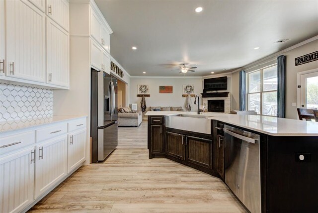 31352 Landrun Ave, Norman, OK 73072 - kitchen with stainless steel appliances, open floor plan, a fireplace, a sink, and ceiling fan