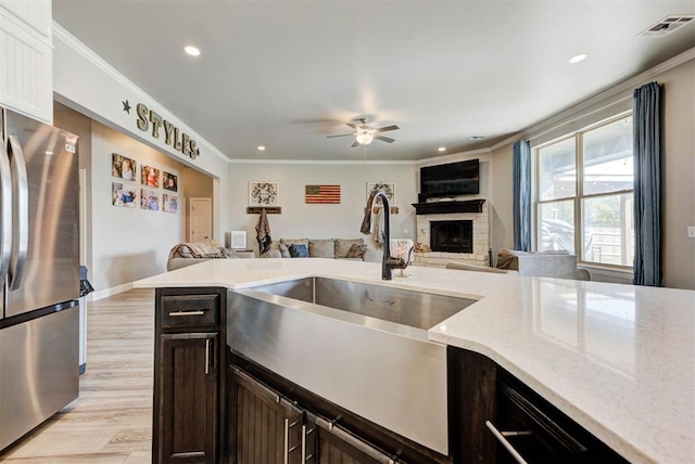 31352 Landrun Ave, Norman, OK 73072 - kitchen featuring freestanding refrigerator, a sink, open floor plan, a fireplace, and a ceiling fan
