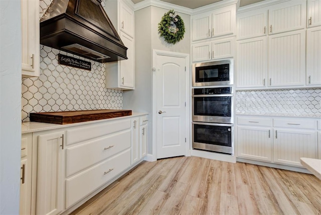31352 Landrun Ave, Norman, OK 73072 - kitchen with premium range hood, double oven, built in microwave, backsplash, and crown molding