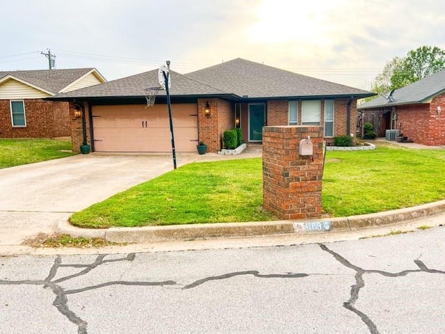1189 N Blue Ridge Dr, Purcell, OK 73080 - view of front facade featuring central AC unit, a garage, concrete driveway, brick siding, and a front lawn