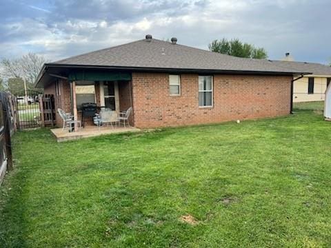 1189 N Blue Ridge Dr, Purcell, OK 73080 - rear view of property with a yard, a patio area, fence, and brick siding