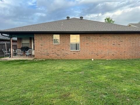 1189 N Blue Ridge Dr, Purcell, OK 73080 - back of house featuring a lawn, a patio area, brick siding, fence, and a shingled roof