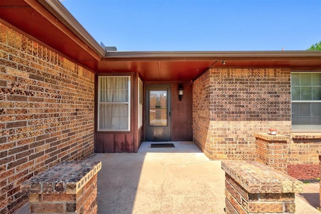 1809 W Aqua Clear Dr, Mustang, OK 73064 - view of exterior entry with a patio area and brick siding