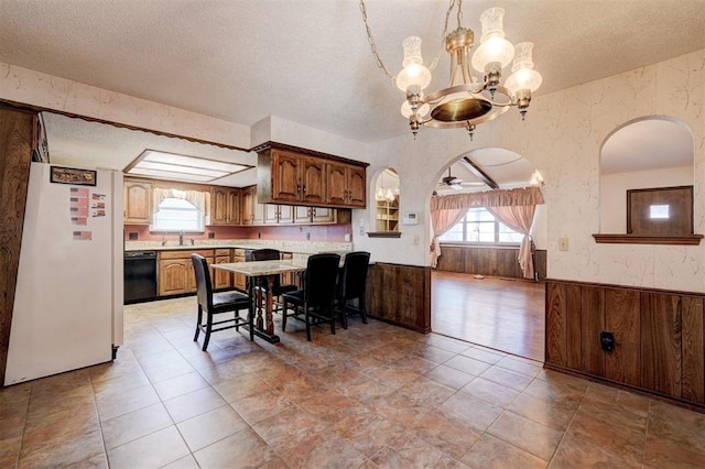 1809 W Aqua Clear Dr, Mustang, OK 73064 - dining space with a notable chandelier, a textured ceiling, wainscoting, and wallpapered walls