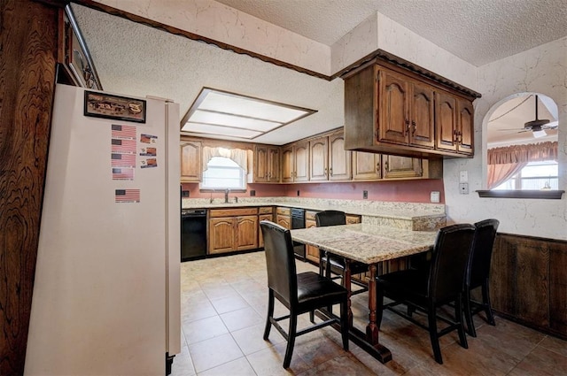 1809 W Aqua Clear Dr, Mustang, OK 73064 - kitchen featuring light countertops, freestanding refrigerator, black dishwasher, and a wealth of natural light
