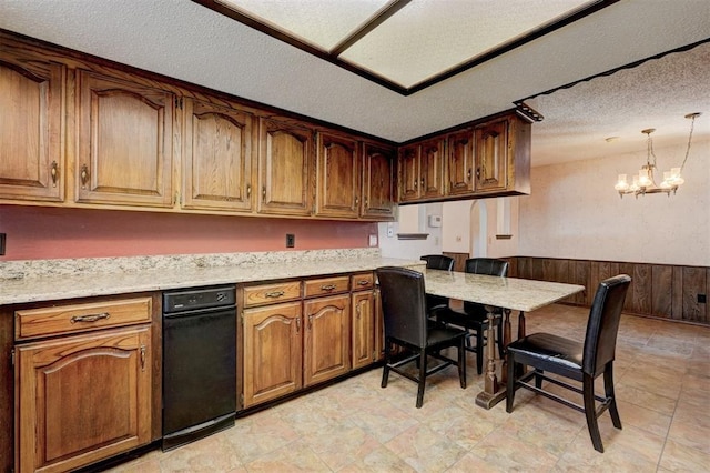 1809 W Aqua Clear Dr, Mustang, OK 73064 - kitchen with a notable chandelier, a textured ceiling, wainscoting, brown cabinets, and pendant lighting