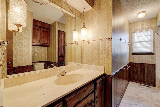 1809 W Aqua Clear Dr, Mustang, OK 73064 - bathroom featuring a textured ceiling, vanity, visible vents, marble finish floor, and wallpapered walls